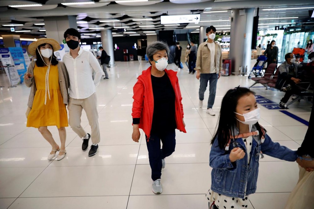 People wearing masks to avoid the spread of the coronavirus disease (COVID-19) arrive at Gimpo international airport in Seoul, South Korea, May 1, 2020. REUTERS/Kim Hong-Ji